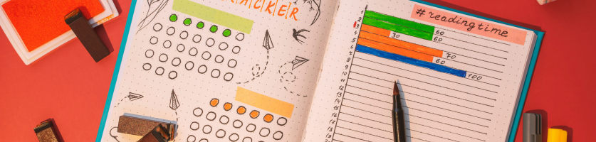 Foto van bovenaf waarop iemand te zien is die bezig is met een bullet journal