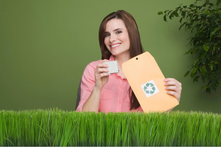 vrouw in een kantooromgeving die enthousiast een recycle-logo omhoog houdt