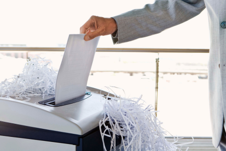 papierversnipperaars onder een bureau en in een thuisomgeving